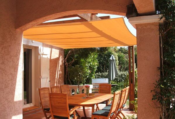 Ademend schaduwdoek boven een terras met pergola